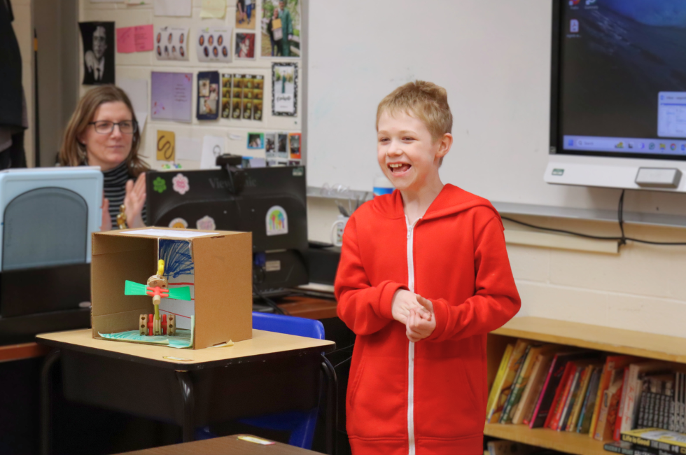 During classroom presentations, a student smiles as he explains his diorama.